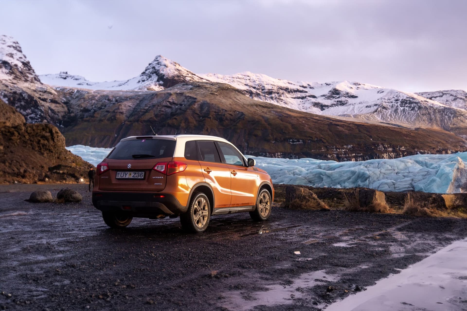 Car on an Icelandic road with a glacier in the distance